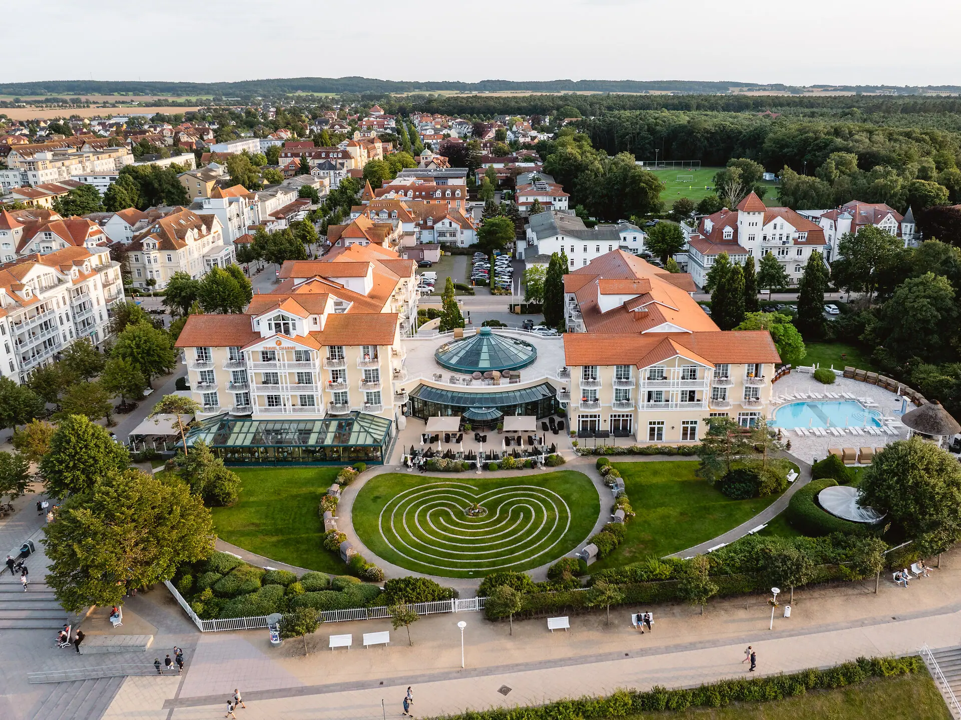 A-ROSA Ostseehotel Kühlungsborn Eine große Gruppe von Gebäuden mit einem Pool und Bäumen.