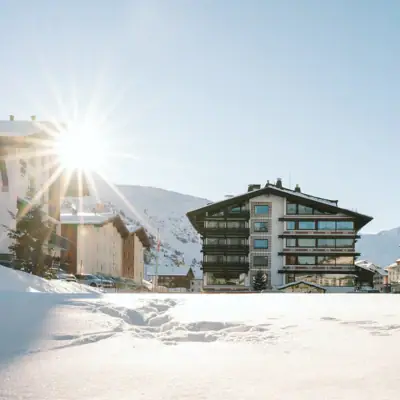 A-ROSA Hotel Zürs Ein Gebäude im Schnee bei klarem Himmel.