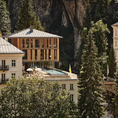 Straubinger Grand Hotel Bad Gastein Ein Gebäude mit einem Pool auf dem Dach, umgeben von Bäumen.