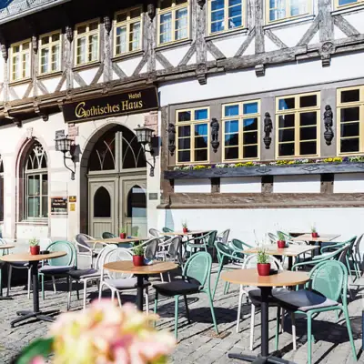 A-ROSA Gothisches Haus Wernigerode Ein Gebäude mit Tischen und Stühlen im Freien.
