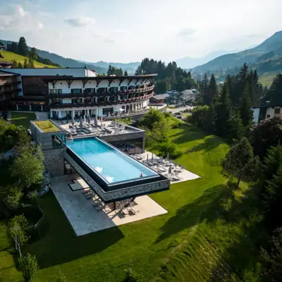 A-ROSA Ifen Hotel Kleinwalsertal Ein Außenpool in einem Hotel mit Bäumen und Himmel im Hintergrund.