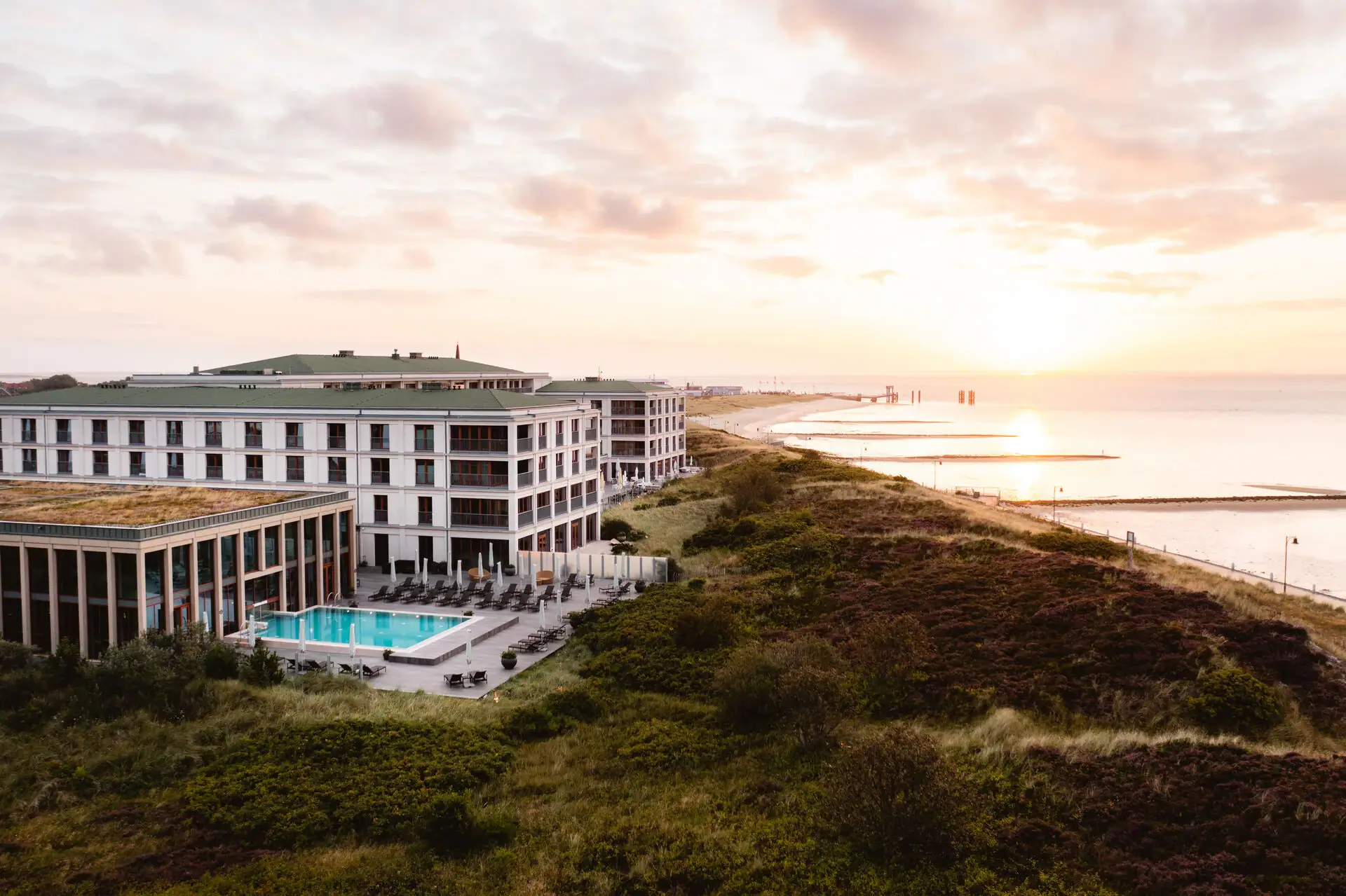 A-ROSA Sylt Ein Gebäude mit einem Pool am Wasser.