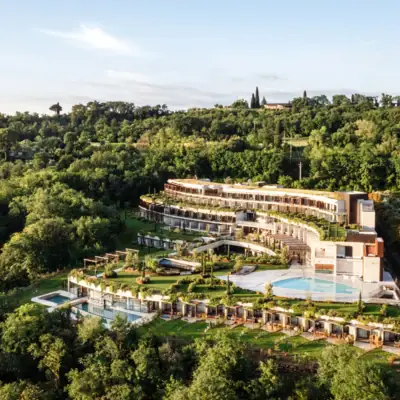 A-ROSA Gardasee Ein Gebäude mit einem Pool, umgeben von Bäumen.